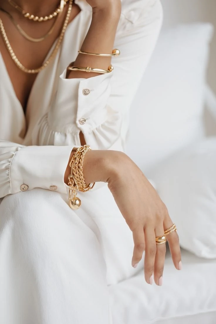 Modelo usando pulseiras, braceletes e colares dourados